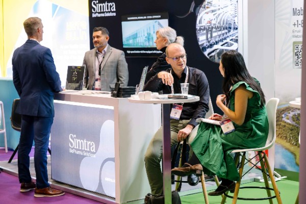 Attendees meeting with exhibitors and discussing technologies at exhibition booths during World ADC London.