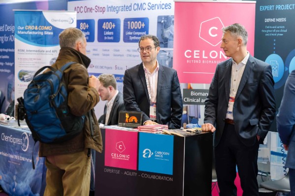 Attendees meeting with exhibitors and discussing technologies at exhibition booths during World ADC London.